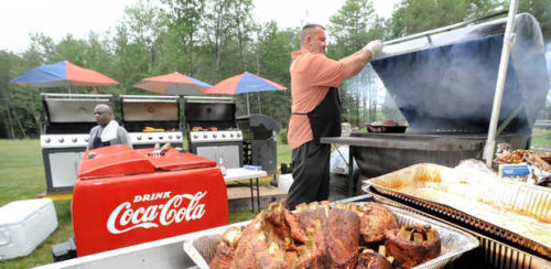 Ron Kyllonen, owner of Moose's Mobile Kitchen, opens the top of a grill in his backyard, where he was preparing a barbecue for an upcoming event recently. (RUSS DILLINGHAM/SUN JOURNAL)