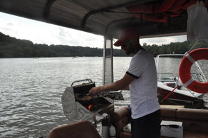 Ari Fingeroth grills up a Nauti dog on his new food boat Nauti Foods. (WTOP/Rachel Nania)