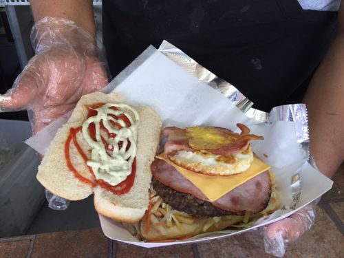 The burger, completed, topped in four sauces and three kinds of meat.  Photo by Patrick Hieger