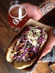 The Asian-style pulled pork sandwich at Nomad Street Cuisine features Korean barbecue sauce and orange ginger coleslaw, pictured with a Funkwerks beer. (Photo: Courtesy of Blake Shepler)