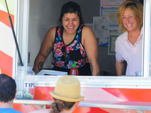 Rachel Khable and Michelle Silva, owner of Las Olas, laugh with customers at the 5th Annual Vendy Awards on the JFK Bridge in Philadelphia on Saturday, June 13, 2015. ( MICHAEL PRONZATO / Staff Photographer )