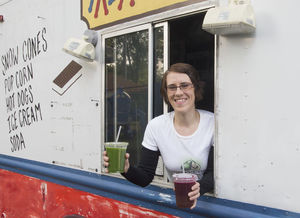 Jessie Miles leans out the window of the new food truck she recently purchased — and has not yet repainted — and holds some of the fresh juices she plans to sell. Miles hopes to open her mobile restaurant called The Grateful Green in the next few months in downtown South Bend if the city approves food truck operations. SBT Photo/BECKY MALEWITZ