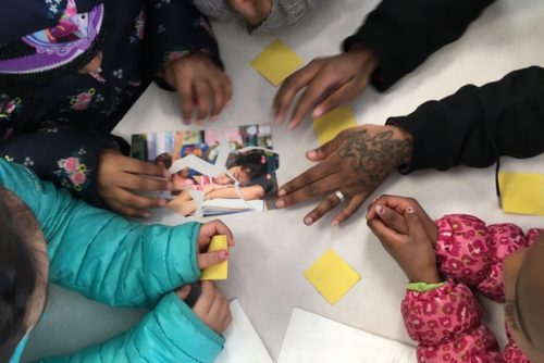 With the help of an Eastman Egg staffer,  students piece together a puzzle showing a tired- looking girl who, they agree, probably didn't eat a good breakfast.  [DNAinfo/Janet Rausa Fuller]