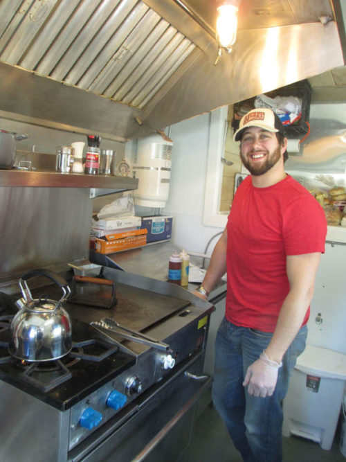 Matthew Glatz stands ready to cook inside his "tiny house" food truck, The SaltBox Cafe,  on Sunday River Road in Newry. He offers a genuine daily perk: The first customer gets a free coffee.