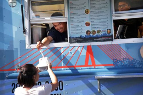 Take a look at some of Seattle's best-named food trucks. Above, Ferry Ijaya hands an order out the window of the Thai-U-Up food truck to Kylie Knowles on Tuesday. Knowles is a frequent patron of the truck; her go-to dish is the Veggie Delight.