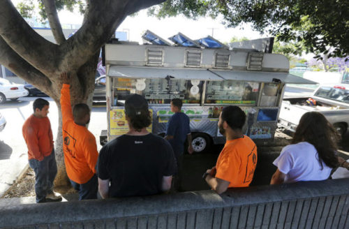 Customers wait for their orders to be made outside the Tacos Ariza food truck on April 28, 2016, in Los Angeles. LOS ANGELES TIMES