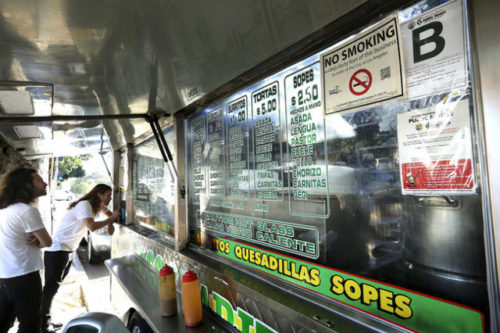 Customers prepare to make their orders at the Tacos Ariza food truck April 28, 2016, in Los Angeles. Food trucks have scored poorly on health inspections. LOS ANGELES TIMES