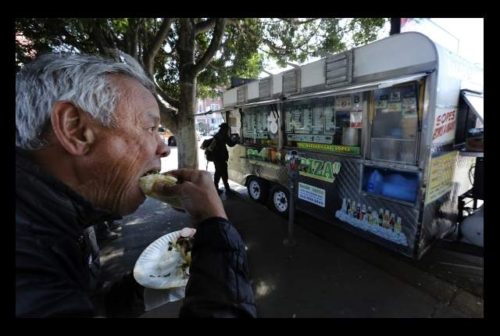 Terril Johnson bites into a taco he purchased from the Tacos Ariza food truck April 28, 2016, in Los Angeles. Food trucks have scored poorly on health inspections. Tacos Ariza got a C grade in March and was re-inspected and now has a B grade.
