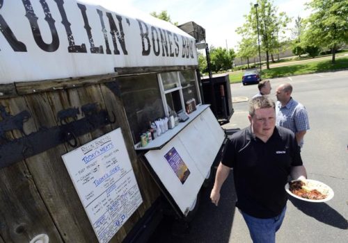 David Porter collects his meal from a food truck, Rollin' Bones BBQ, which was serving food on Central Avenur in Boulder on Friday. (Cliff Grassmick / Staff Photographer)